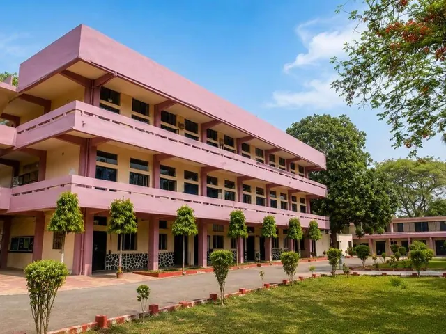 A pink three-storey college building with landscaped grounds