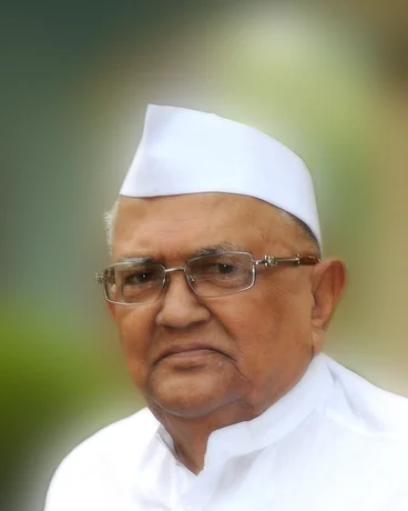 Portrait of the late Annasaheb P. K. Patil in a white cap and glasses